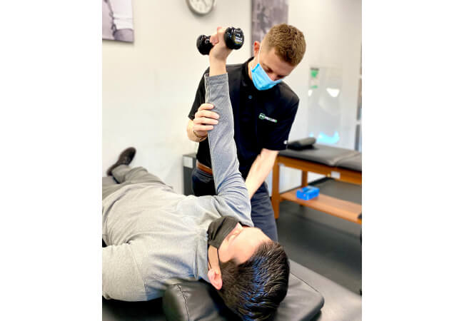 A physical therapist assisting patient with physical therapy exercise